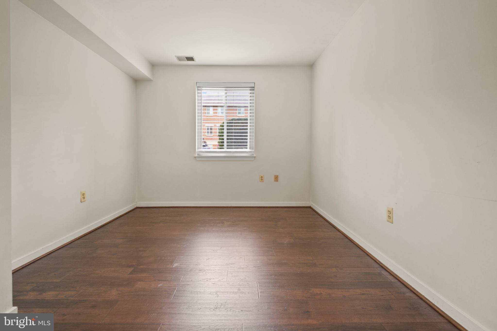 123 West Conway Street, Unit R 58 Baltimore, MD 21201 - Photo 19 of 20 an empty room with wooden floor and windows