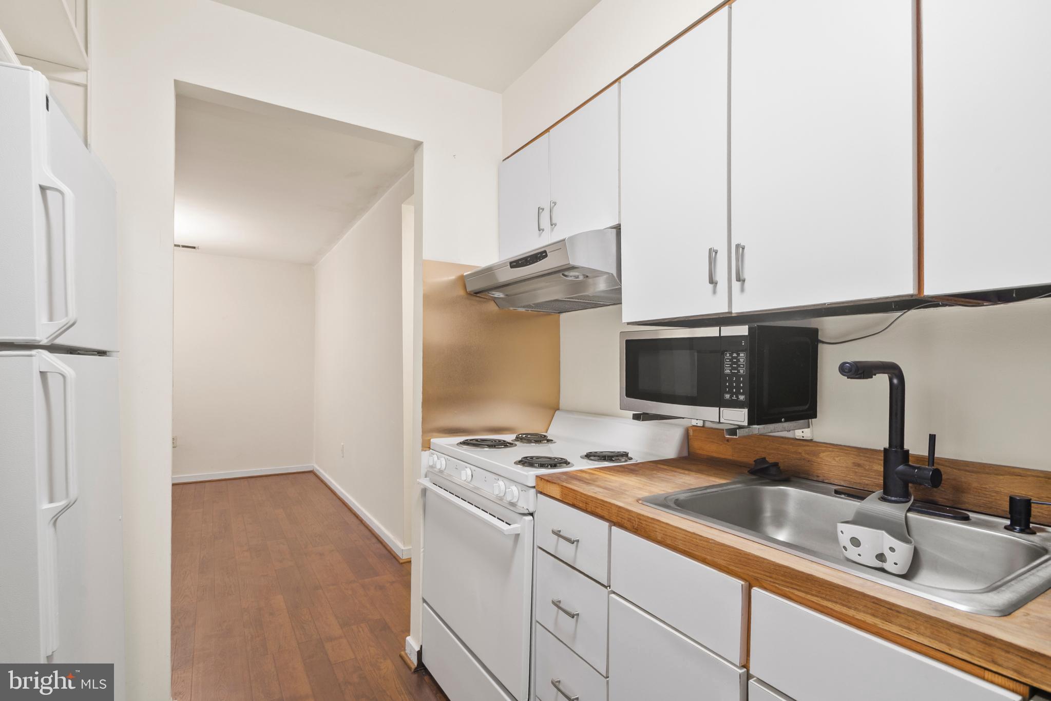 123 West Conway Street, Unit R 58 Baltimore, MD 21201 - Photo 10 of 20 a kitchen with granite countertop a sink and a stove top oven