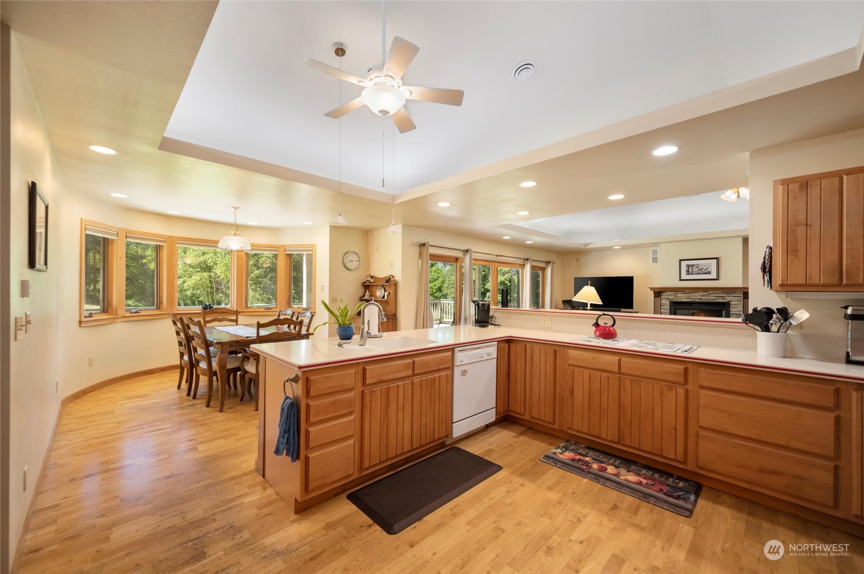 7445 Valley View Road Ferndale, WA 98248 - Photo 8 of 39 a large kitchen with kitchen island a sink a stove a dining table and chairs with wooden floor