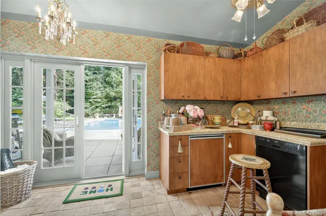 a kitchen with granite countertop a stove a sink a refrigerator and wooden cabinets