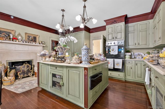 a kitchen with a stove and a white cabinets with wooden floor