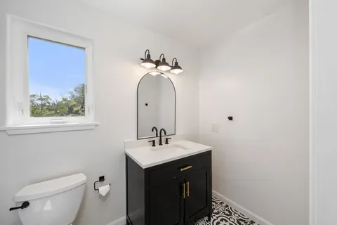 a bathroom with a sink a toilet and a mirror