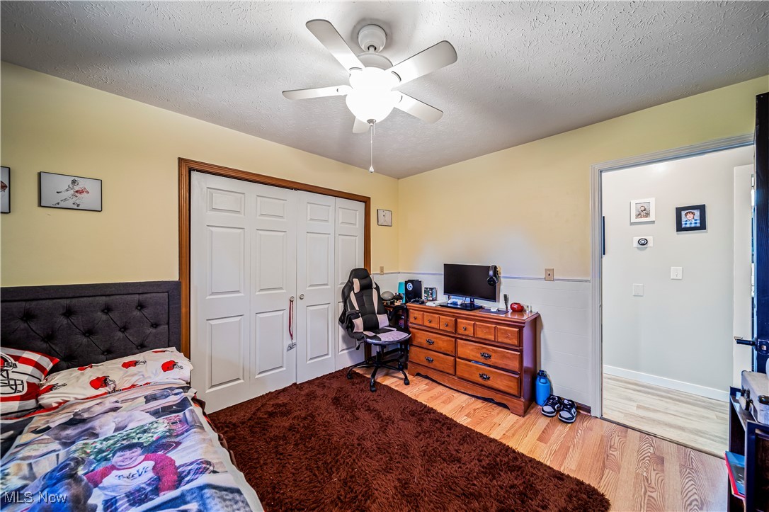 4188 State Road South Ashtabula, OH 44004 - Photo 21 of 46 Bedroom featuring a textured ceiling, wood-type flooring, a closet, and ceiling fan