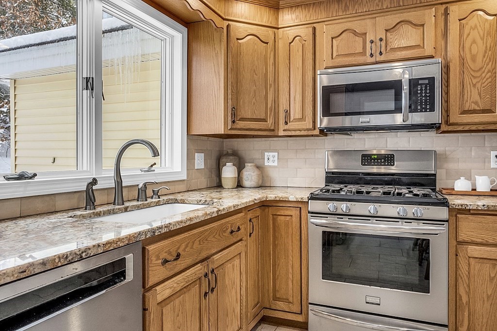25 Ansie Road Chelmsford, MA 01824 - Photo 21 of 41 a kitchen with granite countertop a stove top oven microwave and cabinets