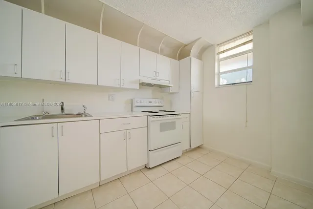 a kitchen with white cabinets and white appliances