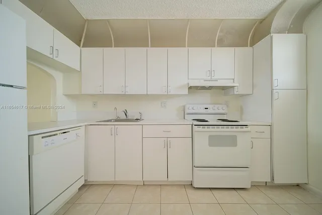 a kitchen with cabinets appliances a sink and a stove