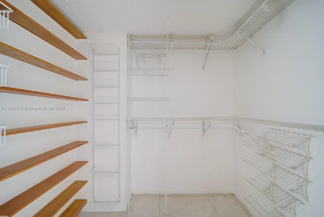 a view of walk in closet with empty racks