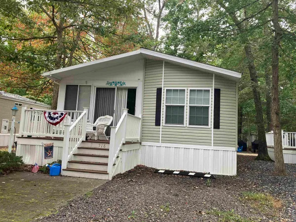 a view of a house with a yard and stairs