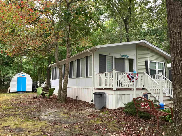 a view of a white house with a sink and a yard