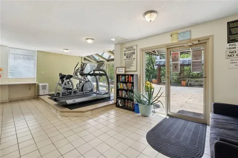 a living room with furniture gym equipment and a floor to ceiling window