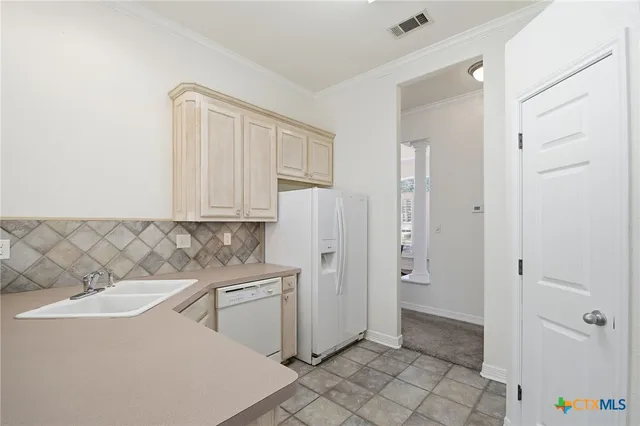 a kitchen with stainless steel appliances granite countertop a stove a sink dishwasher a refrigerator and white cabinets with wooden floor