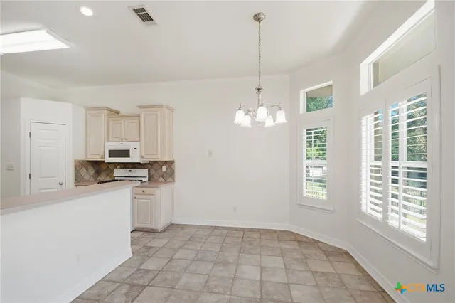 a view of a livingroom with a chandelier fan and a fireplace
