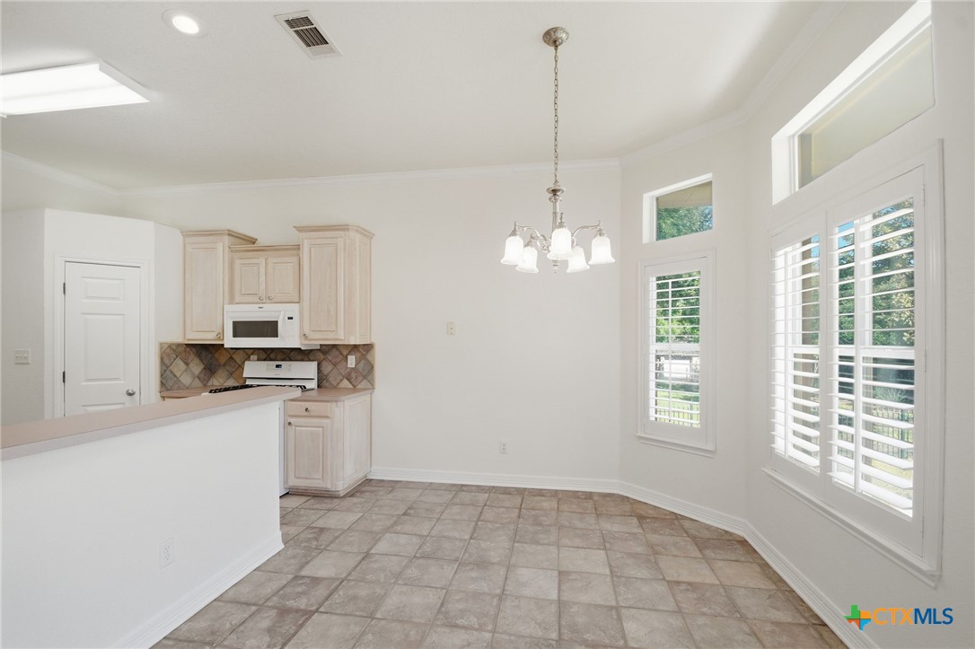4703 Sunflower Lane Temple, TX 76502 - Photo 13 of 35 a kitchen with stainless steel appliances granite countertop a stove a sink dishwasher a refrigerator and white cabinets with wooden floor