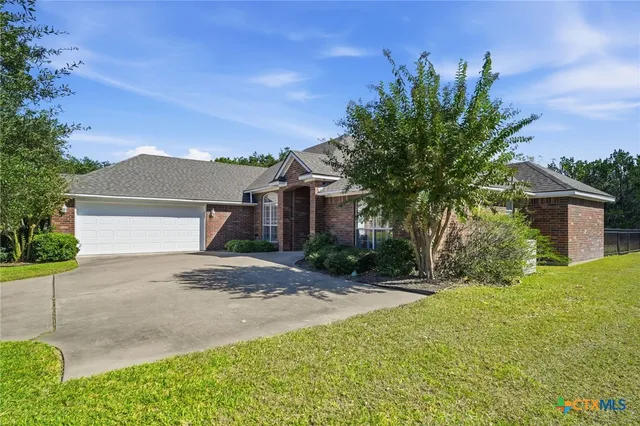 a front view of a house with a yard and a garage