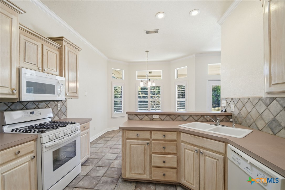 4703 Sunflower Lane Temple, TX 76502 - Photo 10 of 35 a kitchen with granite countertop a sink stove and cabinets