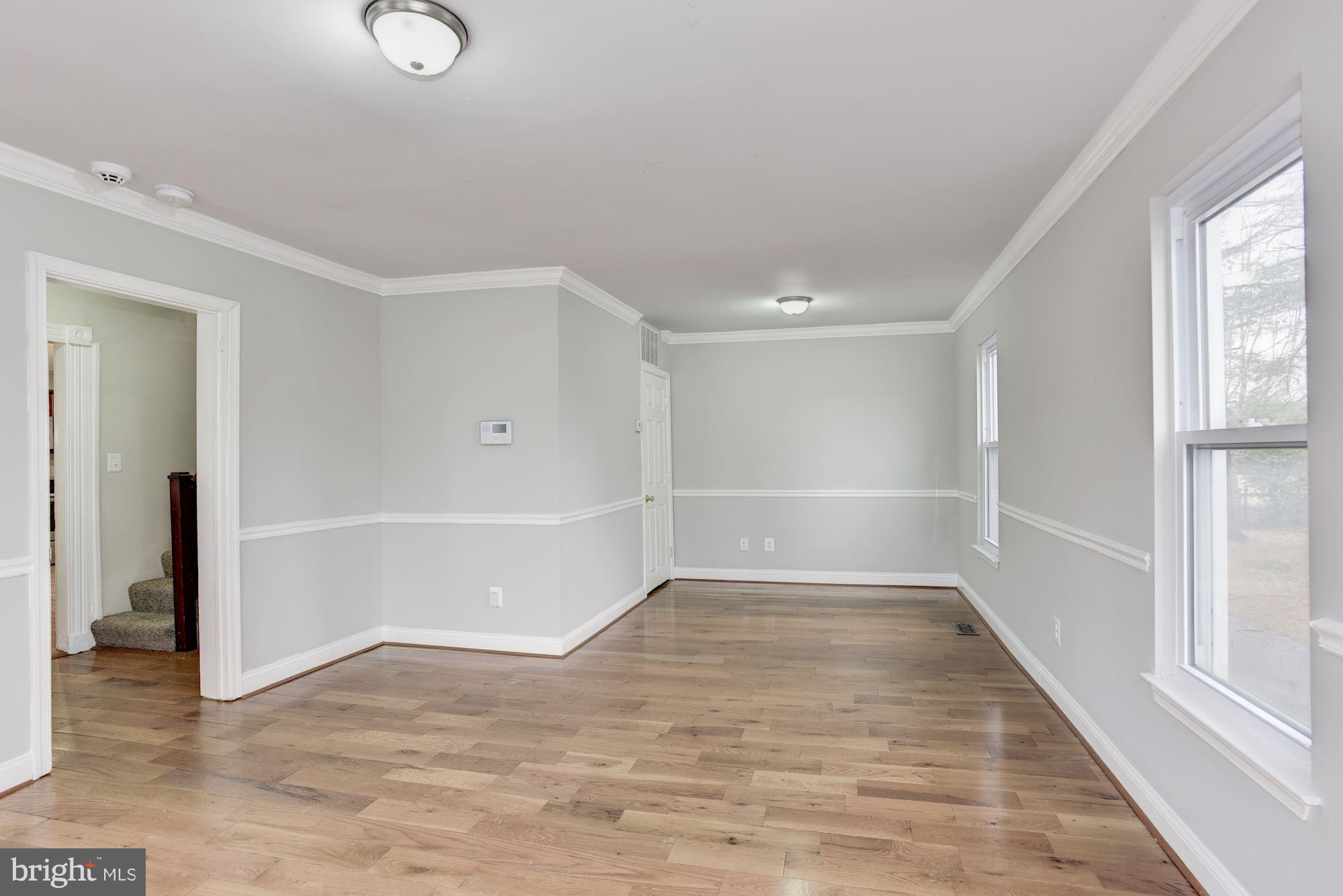 3220 Rolling Rd. Baltimore, MD 21244 - Photo 7 of 28 an empty room with wooden floor and windows