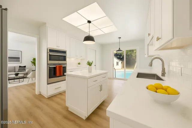a kitchen with a sink stove and wooden floor