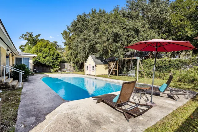 a view of a swimming pool with chairs in patio