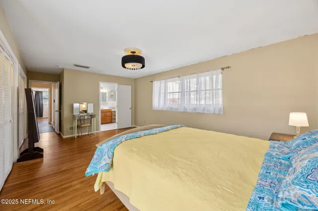 a bedroom with a bed and dresser with mirror