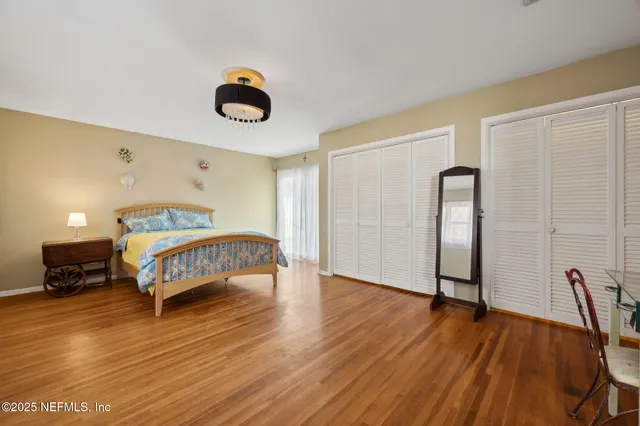 a bedroom with a bed and wooden floor