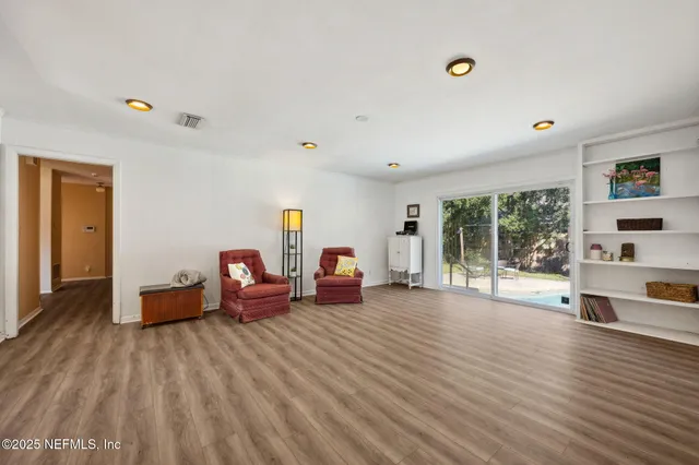 a living room with furniture and a wooden floor