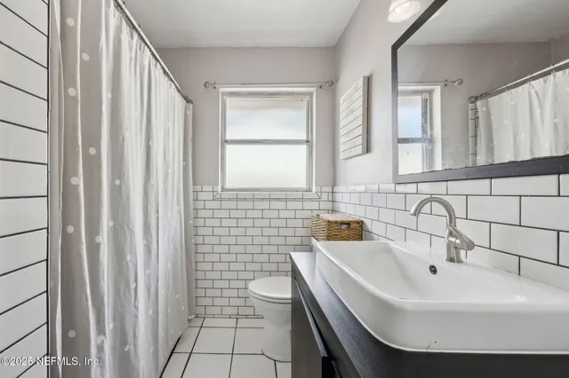 a bathroom with a sink a toilet and mirror