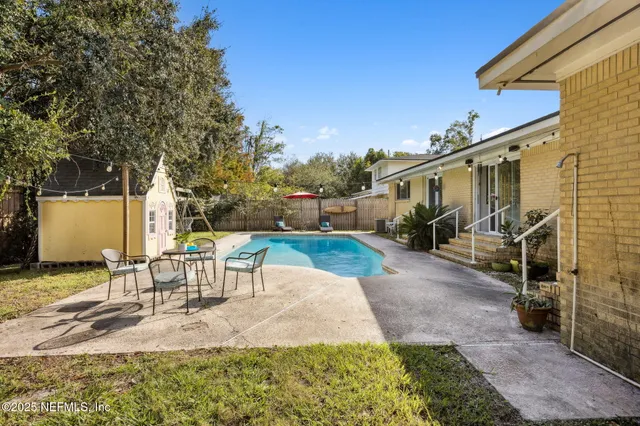 a view of a patio with table and chairs with wooden floor and fence