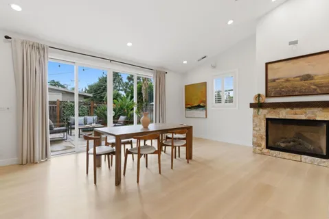 a dining room with furniture a floor to ceiling window and a flat screen tv