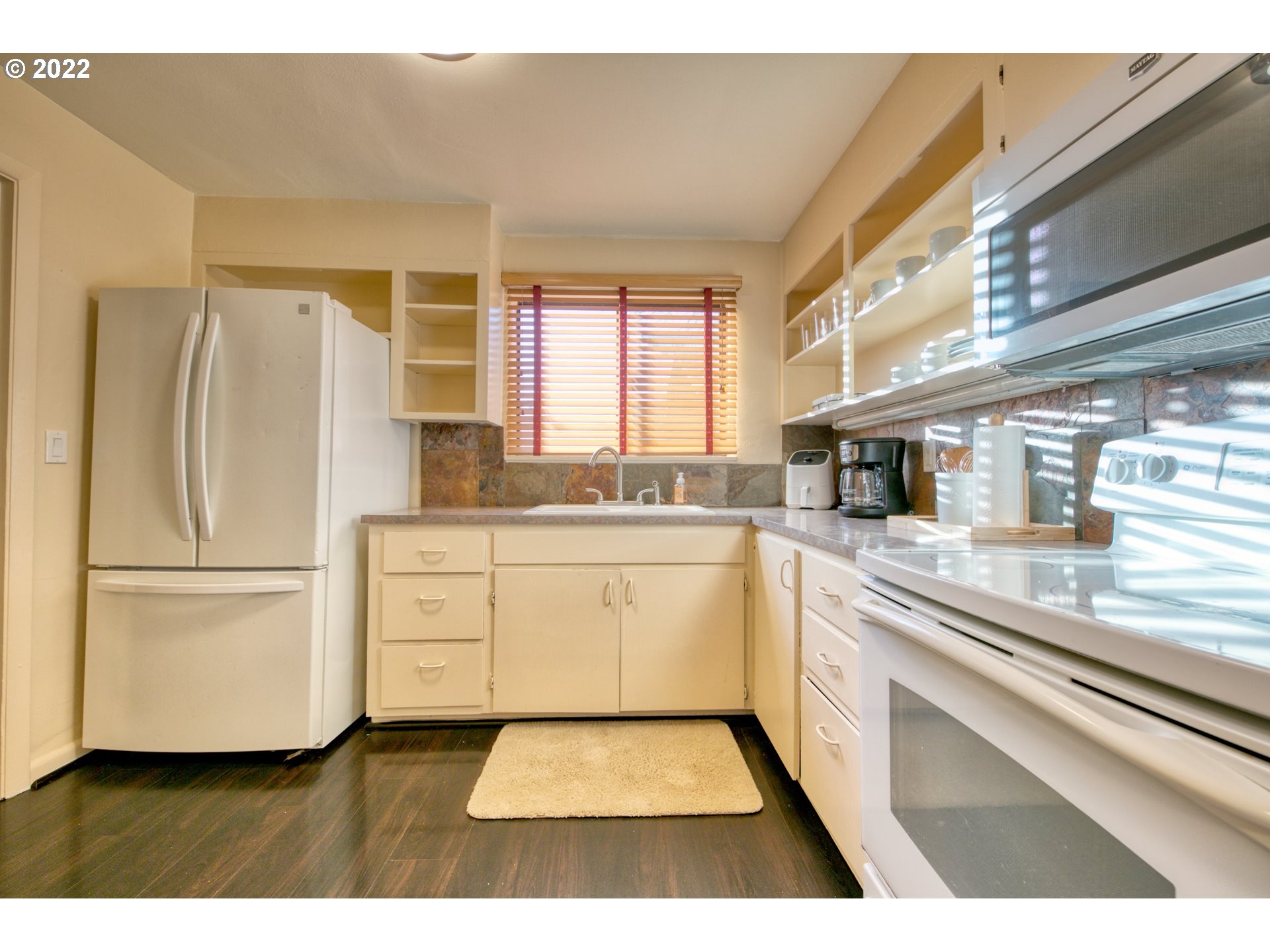 3212 Oriole Street Springfield, OR 97477 - Photo 8 of 20 a kitchen with a refrigerator and white cabinets