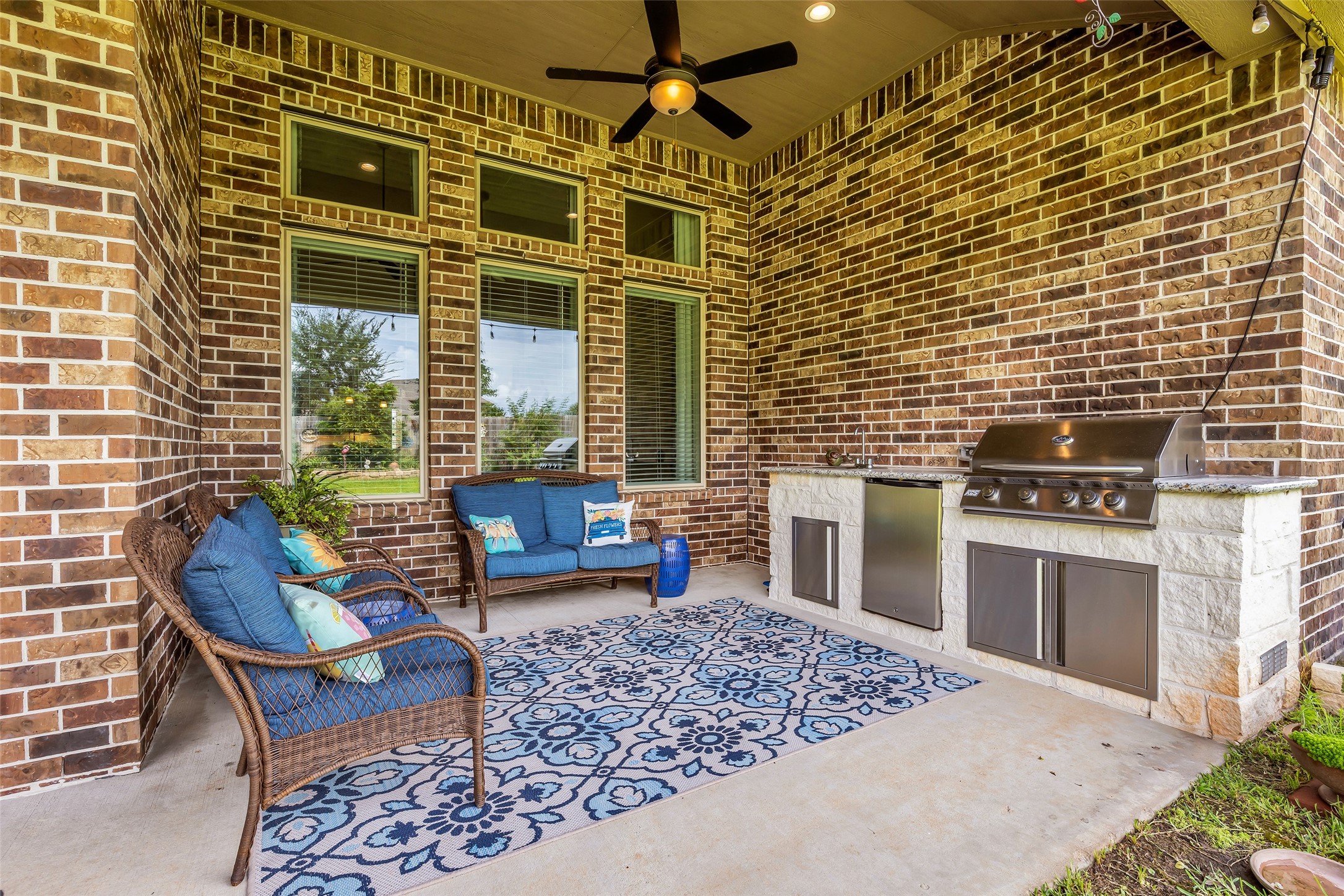 14003 South Evergreen Ridge Court Conroe, TX 77384 - Photo 31 of 43 Covered patio with outdoor kitchen, built-in grill, beverage refrigerator, sink, and ceiling fan.