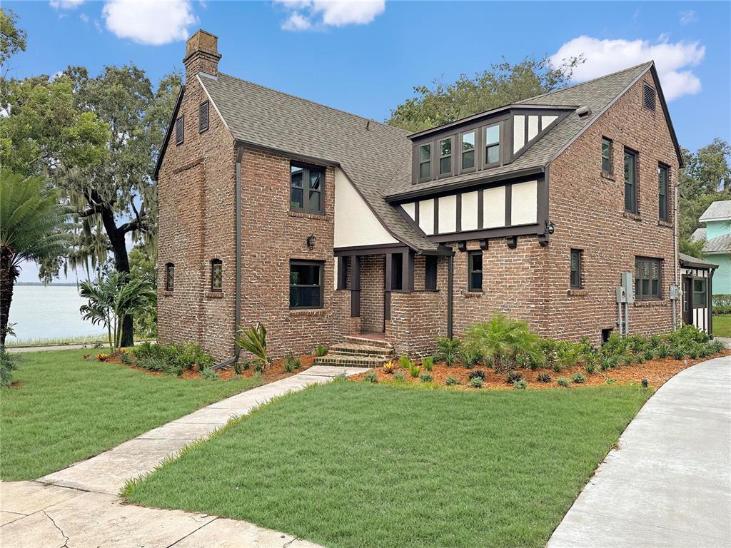 1689 Lakeshore Drive Eustis, FL 32726 - Photo 2 of 76 a front view of a house with a garden and plants