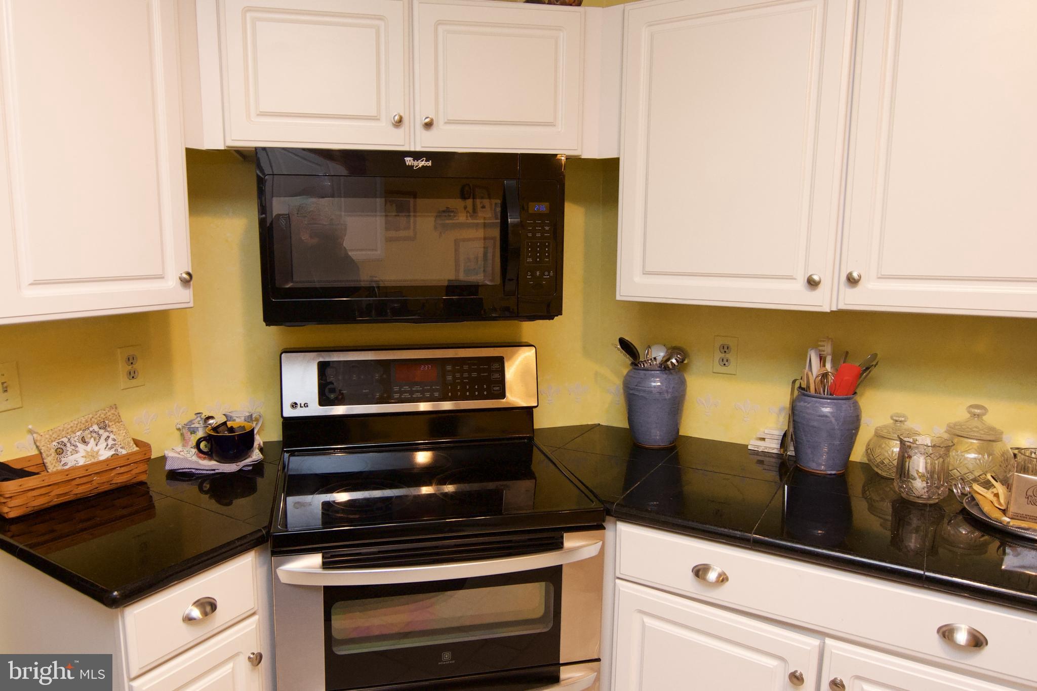 162 Hawthorne Court Reading, PA 19610 - Photo 13 of 32 a kitchen with granite countertop white cabinets and black appliances