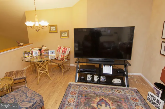 a living room with furniture a flat screen tv and a table