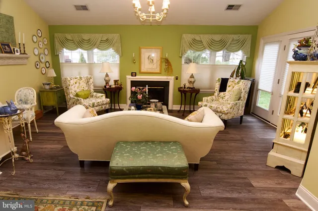 a living room with fireplace furniture and a chandelier