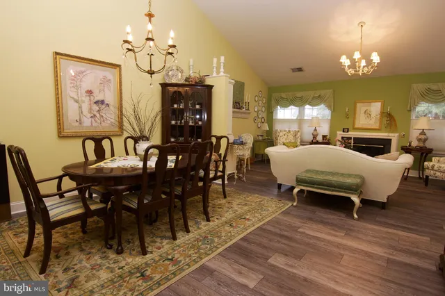 a view of a dining room with furniture a chandelier and wooden floor