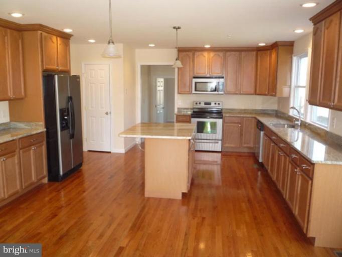 18800 Jerusalem Church Road Poolesville, MD 20837 - Photo 9 of 22 a kitchen with stainless steel appliances wooden floors wooden cabinets and a stove