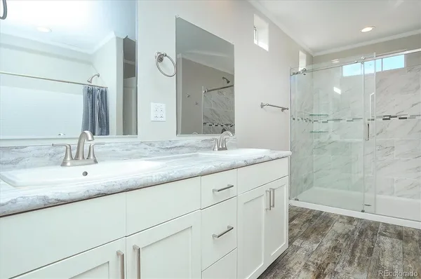 a bathroom with a granite countertop sink a mirror and a shower