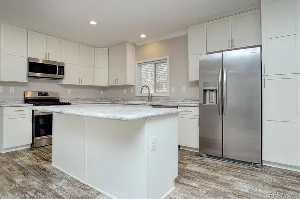 a kitchen with stainless steel appliances granite countertop a refrigerator sink and microwave