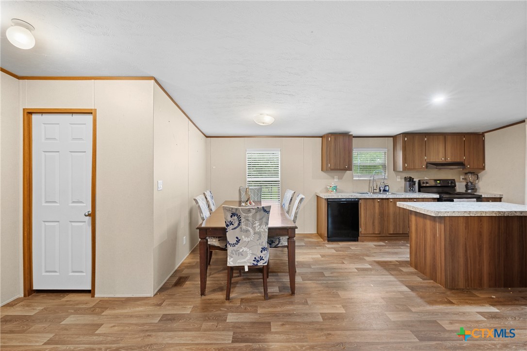 6497 Taylorsville Road Dale, TX 78616 - Photo 5 of 36 a kitchen with stainless steel appliances granite countertop a stove top oven a sink dishwasher and a refrigerator with wooden floor