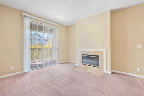 a view of an empty room with a fireplace and a window