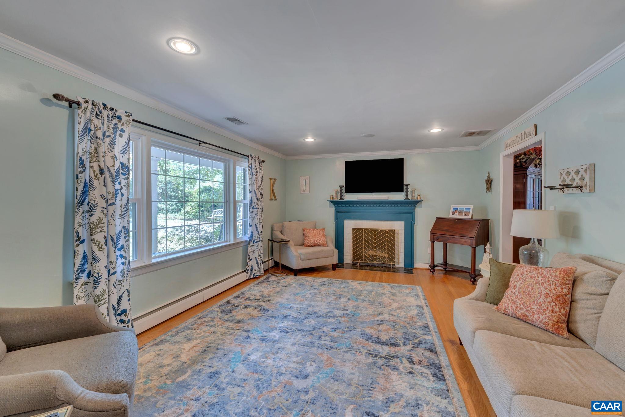 1717 Solomon Road Charlottesville, VA 22901 - Photo 10 of 41 a living room with furniture a fireplace and a flat screen tv