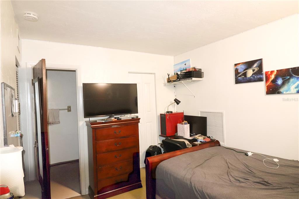 2300 Southwest 43rd Street, Unit T3 ROOM C Gainesville, FL 32607 - Photo 14 of 27 a bedroom with a bed and a flat screen tv
