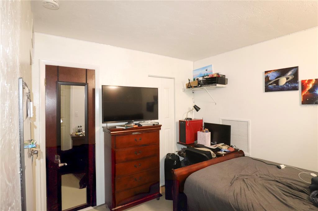 2300 Southwest 43rd Street, Unit T3 ROOM C Gainesville, FL 32607 - Photo 15 of 27 a bedroom with a bed and a flat screen tv