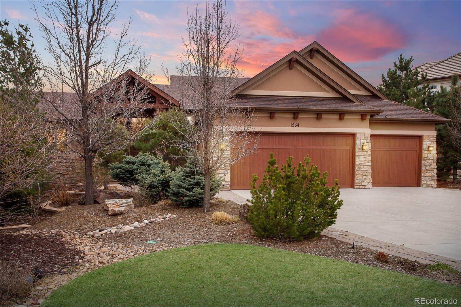 1254 Buffalo Ridge Road Castle Pines, CO 80108 - Photo 1 of 40 a front view of a house with garden