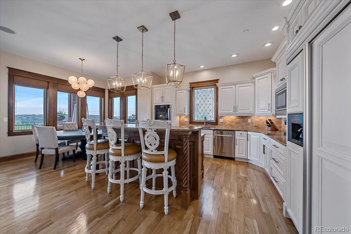 1254 Buffalo Ridge Road Castle Pines, CO 80108 - Photo 13 of 40 a large kitchen with a table and chairs