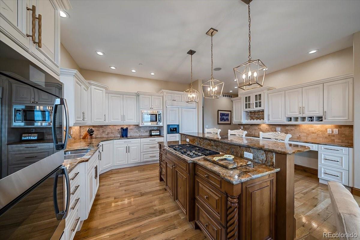 1254 Buffalo Ridge Road Castle Pines, CO 80108 - Photo 15 of 40 a large kitchen with stainless steel appliances granite countertop a stove a sink dishwasher and a wooden cabinets