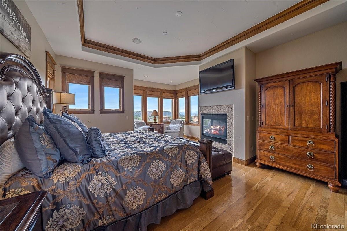 1254 Buffalo Ridge Road Castle Pines, CO 80108 - Photo 17 of 40 a spacious bedroom with a bed and furniture