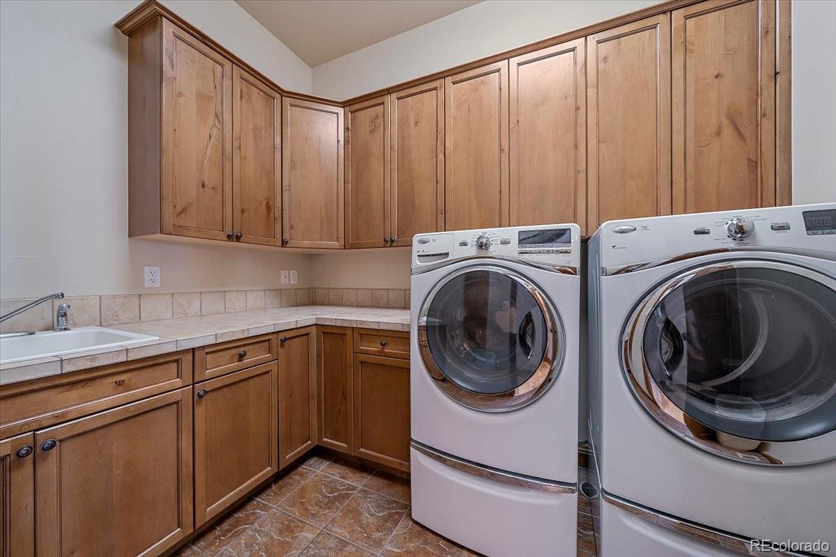 1254 Buffalo Ridge Road Castle Pines, CO 80108 - Photo 22 of 40 a utility room with sink dryer and washer