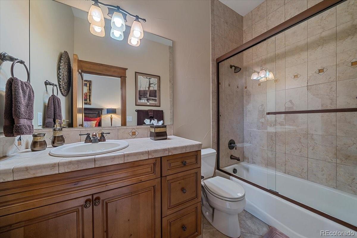 1254 Buffalo Ridge Road Castle Pines, CO 80108 - Photo 33 of 40 a bathroom with a double vanity sink toilet mirror and shower