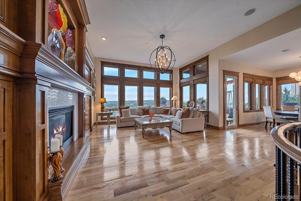 1254 Buffalo Ridge Road Castle Pines, CO 80108 - Photo 7 of 40 a living room with fireplace furniture and a large window